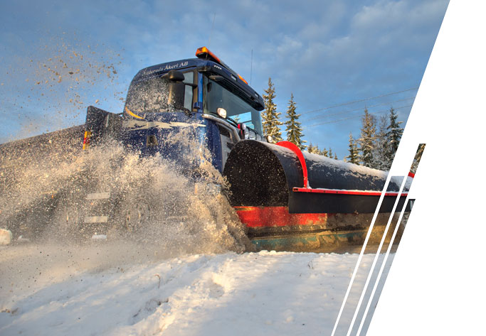 A blue snow plow pushes snow to the left.