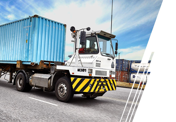 A terminal tractor travels through a port.